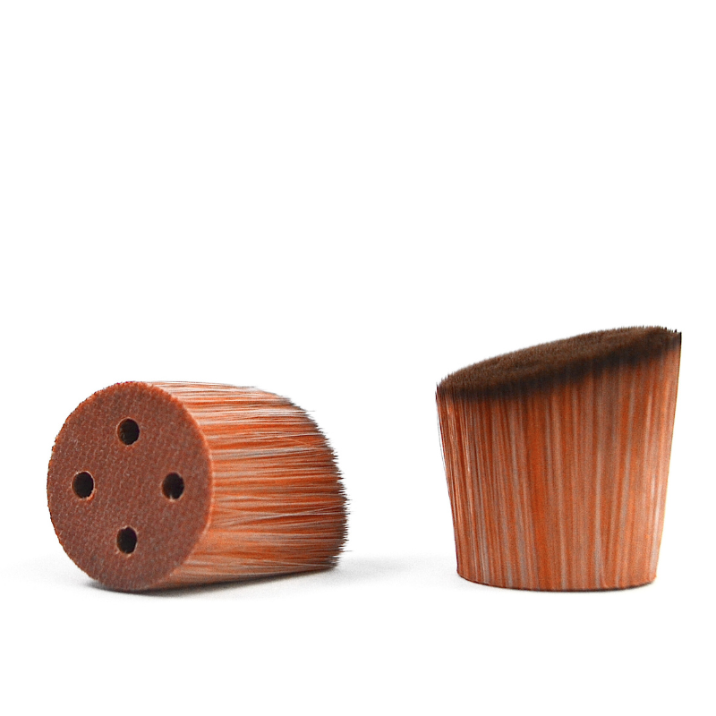 The picture shows two SUNNYBOD™ Replacment Brush Heads. One standing upright on its base and the other laying on its side. The replacement sunscreen brush head has bristles that are dense and are light brown color.