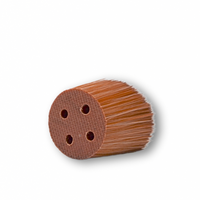 The picture shows a SUNNYBOD™ Replacment Brush Head laying on its side. The replacement sunscreen brush head has bristles that are dense and are light brown color. The base of the brush head is flat, with minor texture. It has four round holes in the bottom that are used to pump the susncreen through onto the brush bristles, when attached to the susncreen applicator brush.