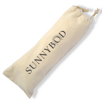 The picture shows an off white cotton fabric SUNNYBOD™ Sunscreen Brush travel Pouch. It has the word "SUNNYBOD" printed in black capital letters vertically down the center. The pouch has a drawstring at the top for opening and closing. The pouch is displayed on a white background. 