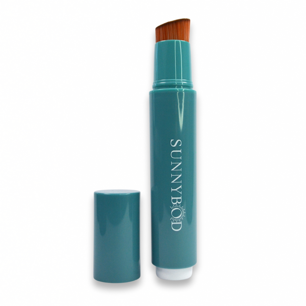 The picture shows a SUNNYBOD™ Refillable Sunscreen Brush Applicator. The brush is turquoise. The susncreen brush bristles are light brown. The handle has the word "SUNNYBOD" written in white capital letters. There is also a turquoise cap next to the brush that can be placed on the brush to cover the bristles. The brush is placed on a white background.